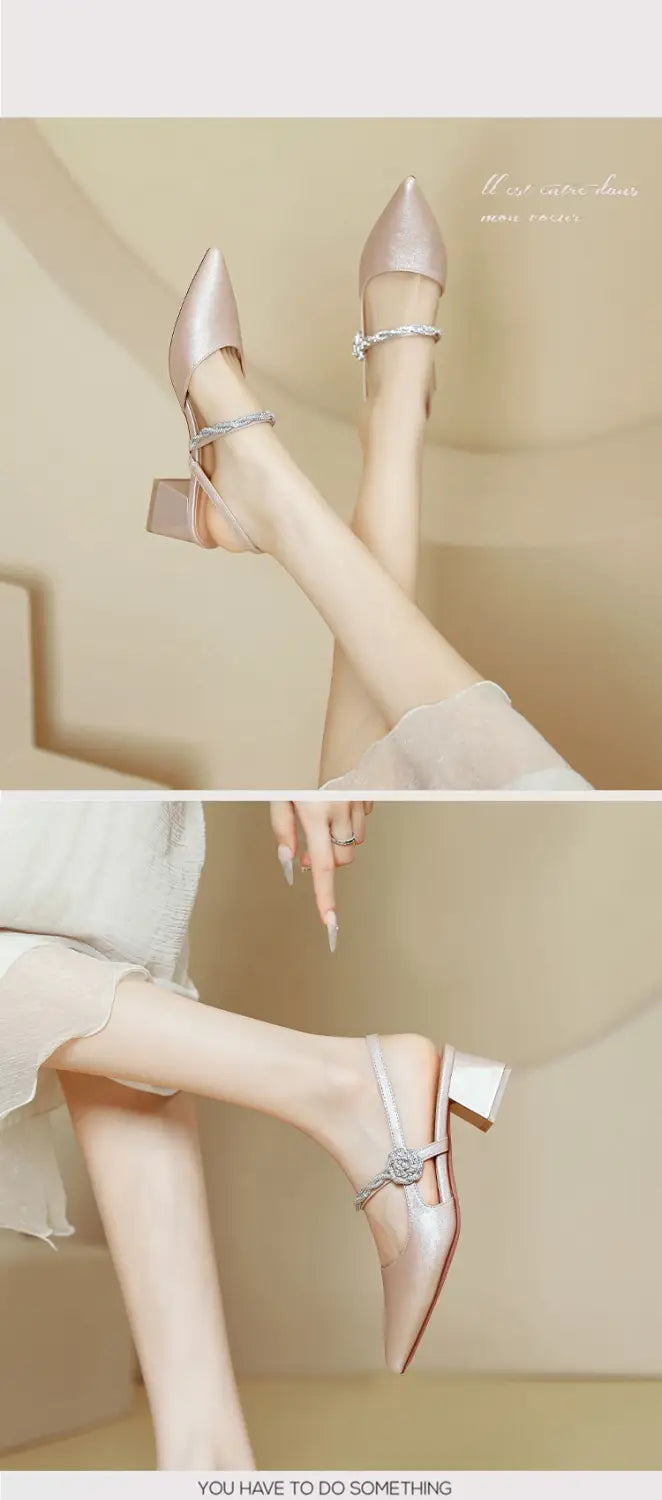 Rose gold satin pointed toe high heels with a chunky heel featuring a delicate ankle strap and small floral embellishment.