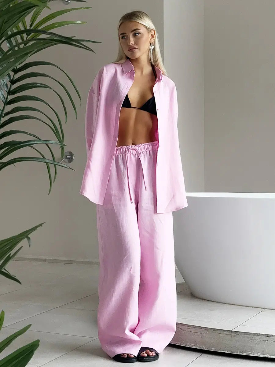 a soft pink oversized linen long sleeve shirt with a relaxed fit and button-down collar paired in a cotton shirt trousers suit