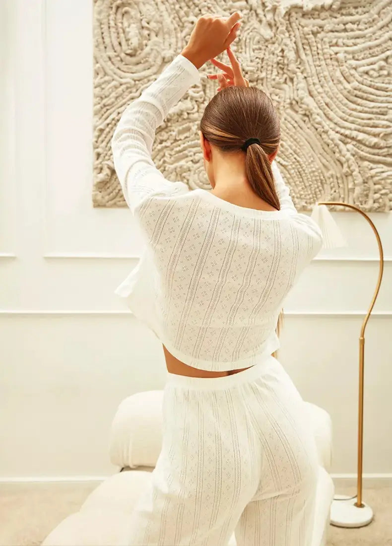 White cropped knit top with subtle vertical ribbing and relaxed fit featuring long sleeve design suitable for fashion cardigan long sleeve styling.