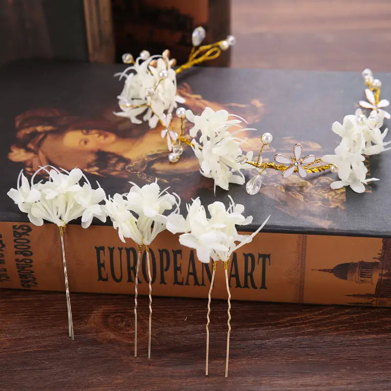 Elegant white floral crystal handmade wreath headwear featuring gold-toned metal stems and delicate pearl accents as handmade wreath headwear.