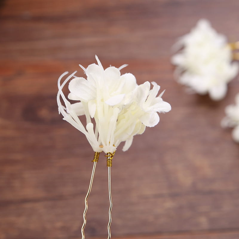 White floral handmade wreath headwear featuring delicate feathery petals and gold-toned wire stems designed for elegant styling.