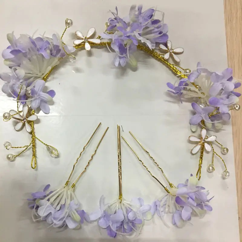 A delicate lavender and white floral handmade wreath headwear adorned with gold wire pearls and crystal accents.