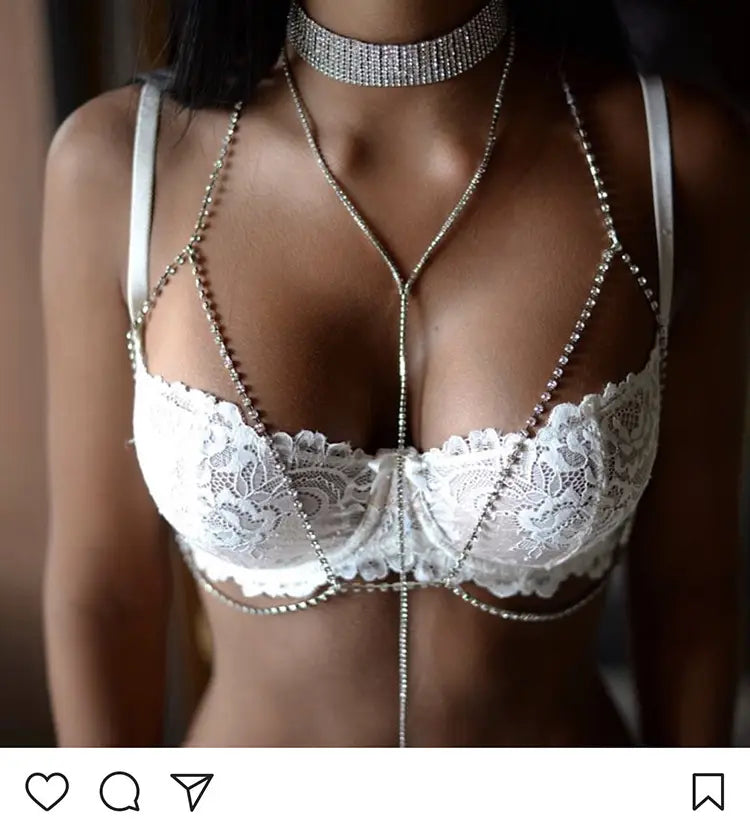 white lace bra featuring silver chain and bead detailing paired with rhinestone body jewelry in a champagne satin blouse ensemble