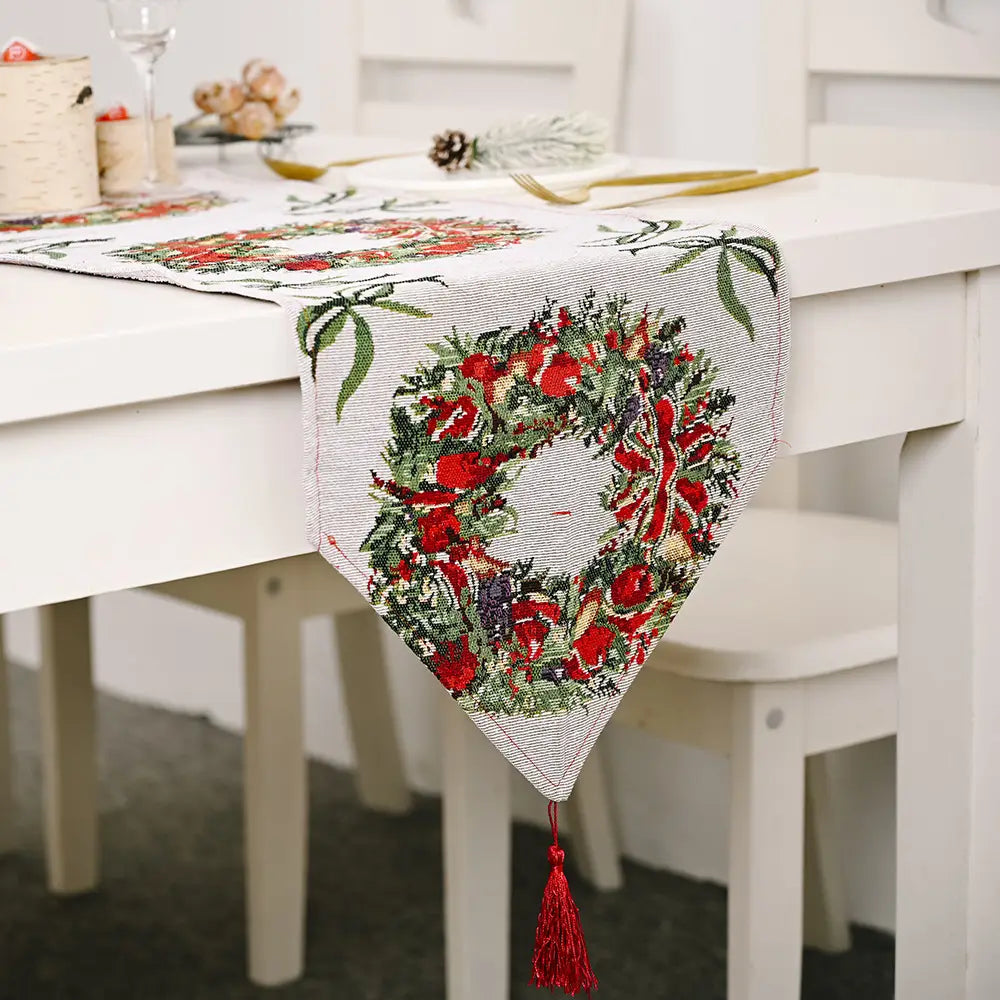 A festive red and green embroidered woven christmas table runner with tassels and holiday patterns for christmas table decoration.