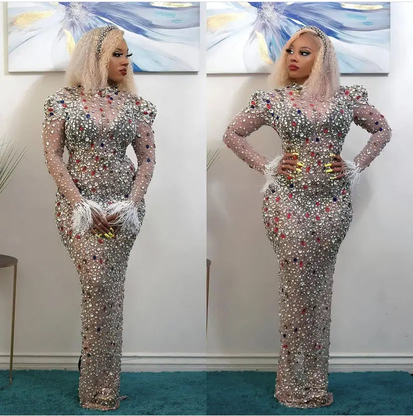 A shimmering silver beaded rhinestone mesh stretch bodycon dress with delicate feather accents at the cuffs designed as a slim american dress.