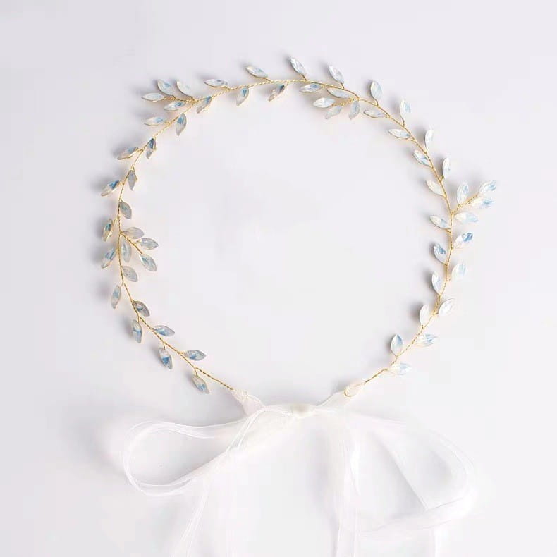 Elegant gold-toned protein rhinestone headdress hair band featuring iridescent silver leaves and a delicate white satin bow.