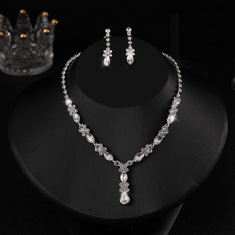 A sparkling silver luxury zircon necklace and earrings set featuring a floral design with clear crystal accents and a dangling teardrop pendant for women’s fashion.