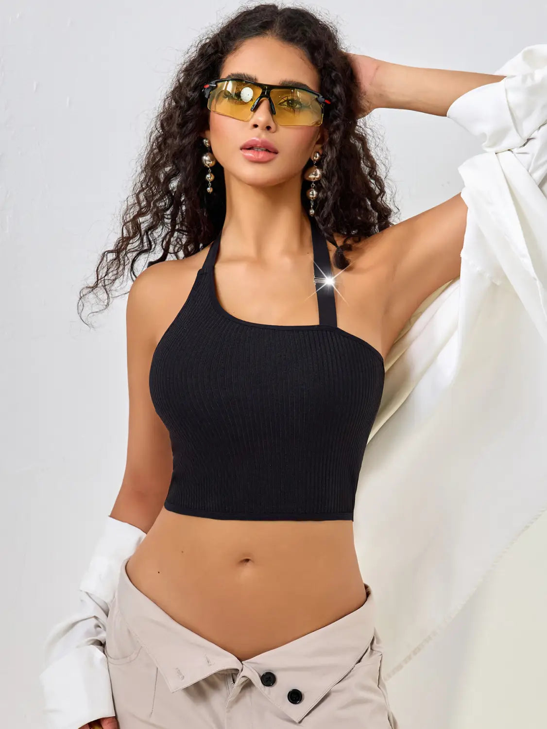 black ribbed halter crop top featuring a solid color low cut one shoulder design in black with a sleeveless style