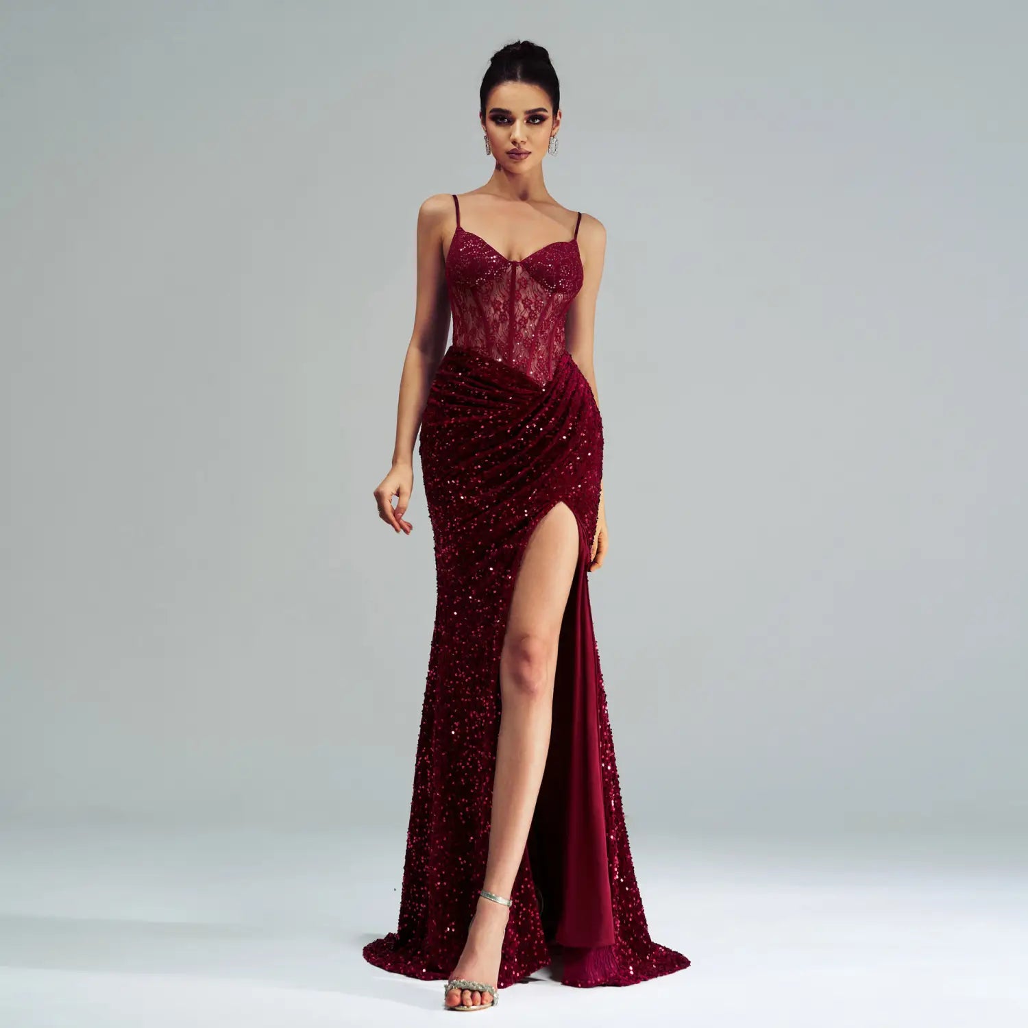 a shimmering burgundy sleeveless sequined high slit evening dress with a lace bodice and spaghetti straps
