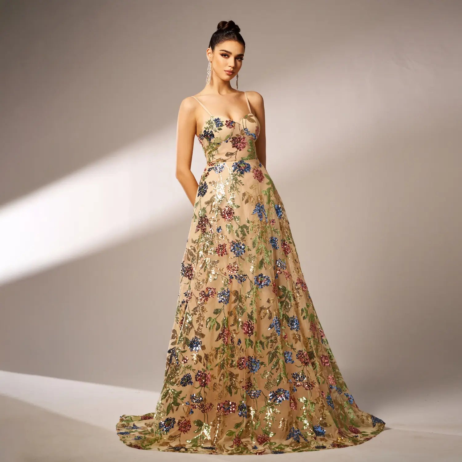 Beige elegant sleeveless sequined suspender evening dress with floral sequin detailing delicate spaghetti straps and a flowing floor-length skirt.