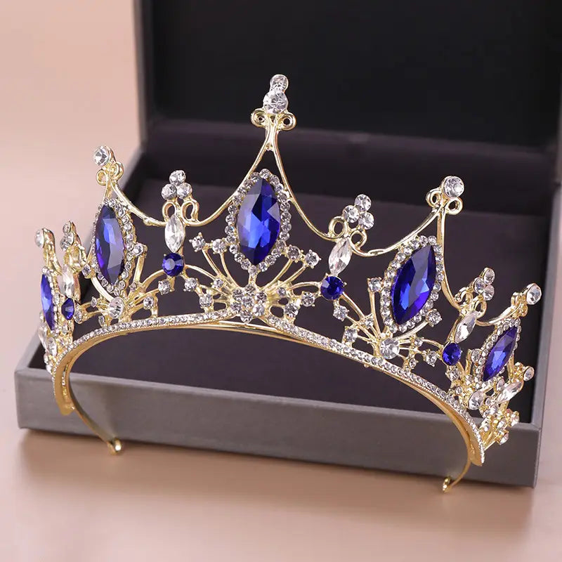 A golden bride golden headband adorned with deep blue and clear crystal stones designed as a crystal crown bride.