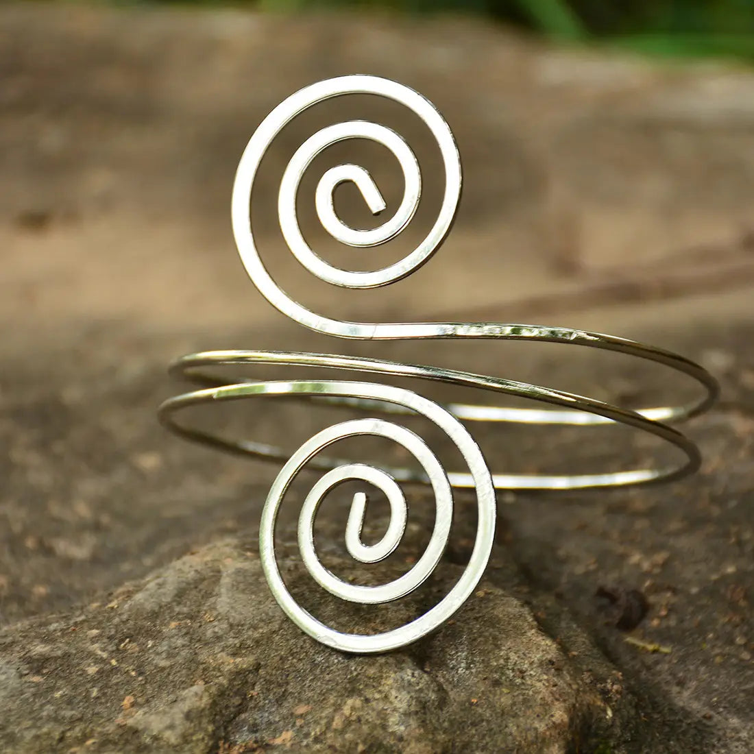 Silver spiral arm ring jewelry featuring a sleek minimalist design with two elegant coiled patterns.