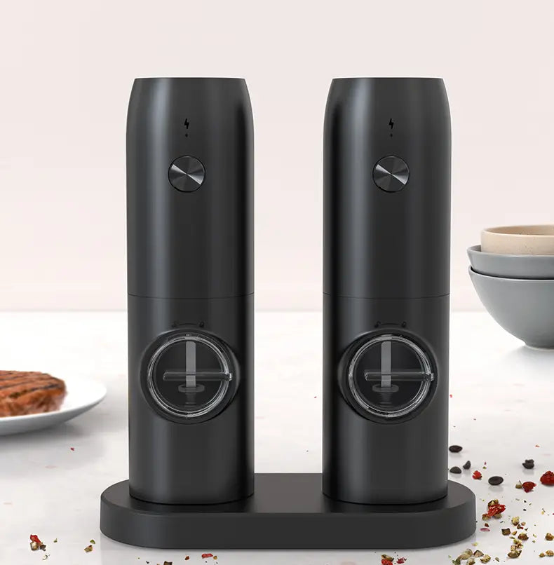 black electric kitchen household pepper and salt grinder set with sleek cylindrical design featuring metallic control knobs and transparent circular windows for precise seasoning.