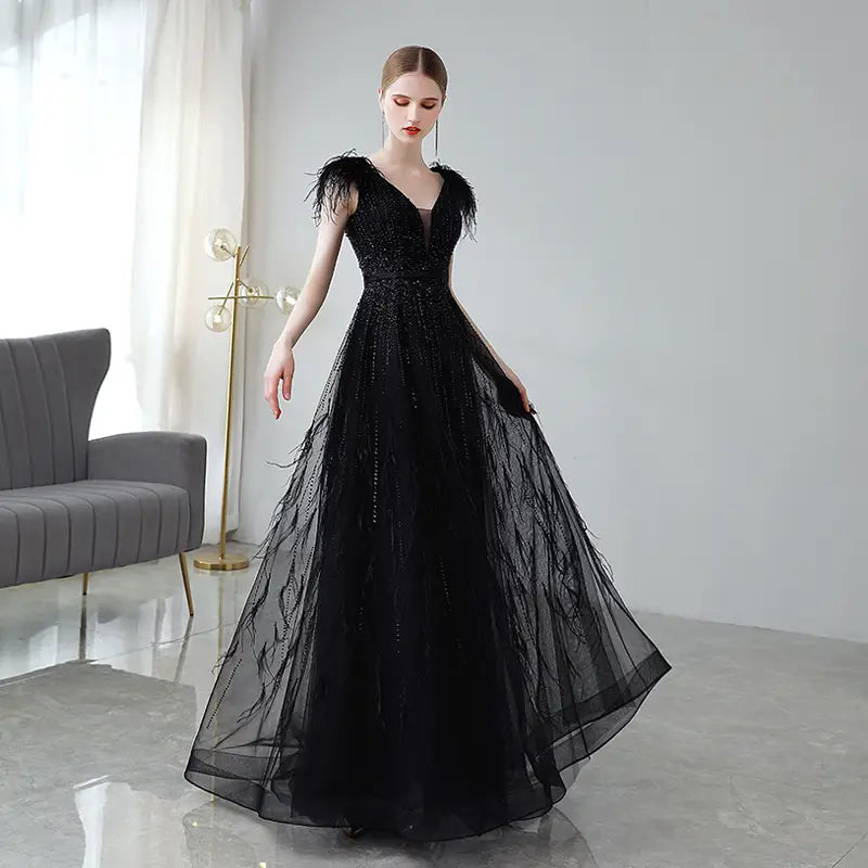 Elegant black double shoulder evening dress featuring feathered shoulder accents and a shimmering sequined bodice.