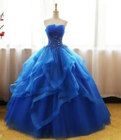 A royal blue strapless ball gown with layered tulle and beaded embellishments showcasing a neatly slim silhouette for wedding dresses.