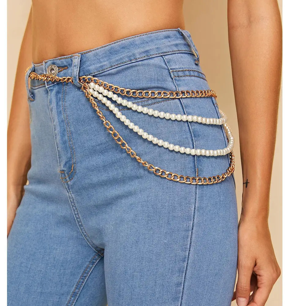 Gold-toned chain belt with three rows of white pearls draped over blue denim jeans is a jewelry accessories waist chain designed for stylish waist decoration.