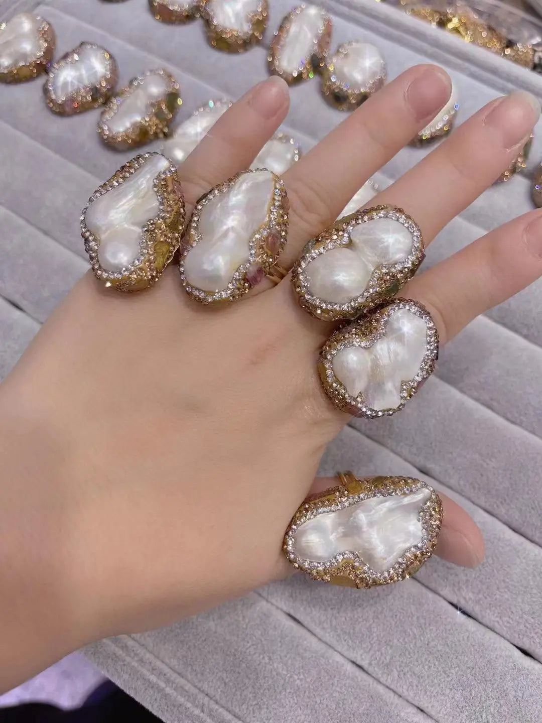 gold-toned gold-toned rings featuring large irregularly shaped baroque pearls surrounded by a halo of sparkling clear stones in a pearl necklace ring suit designed as a ring suit bride ornament.