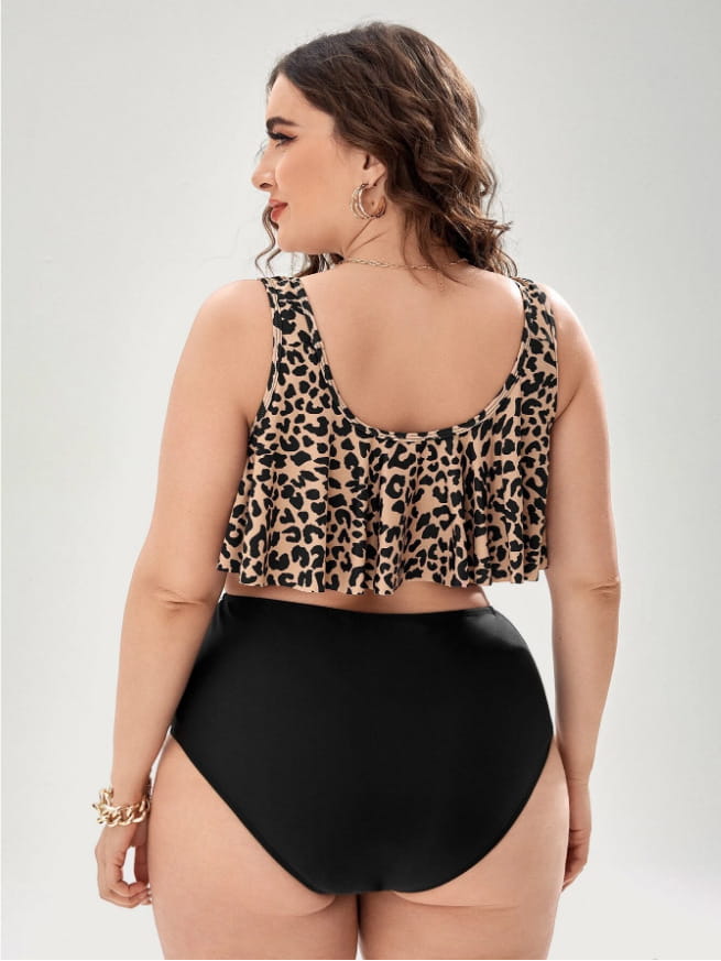 A plus-size leopard print swimsuit featuring a ruffled tankini top and high-waisted black bikini leopard bottoms.