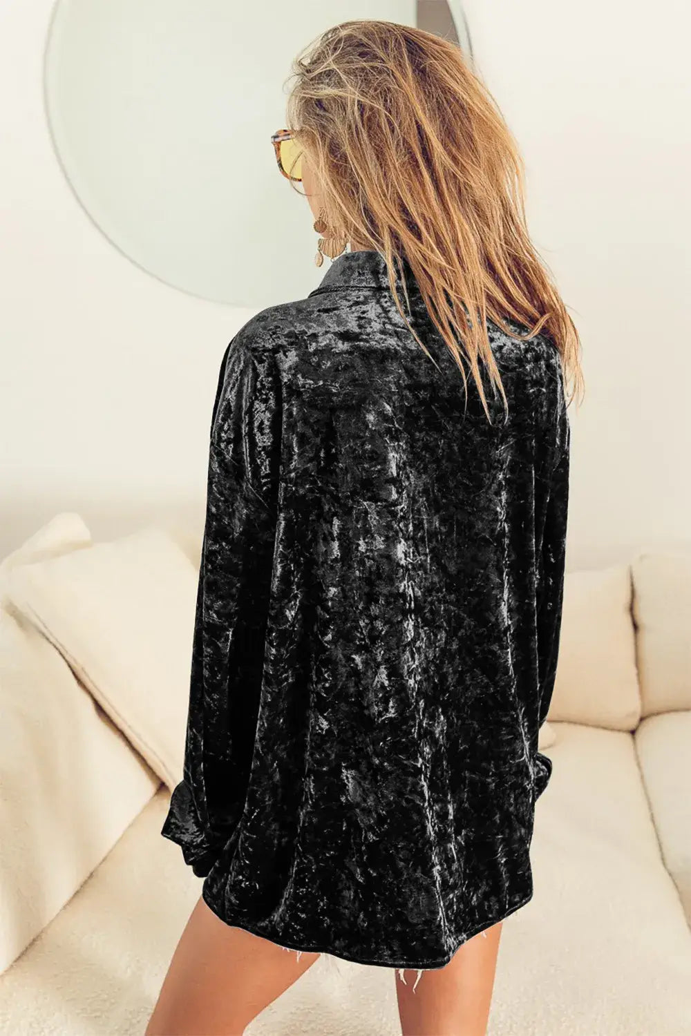 Oversized black long sleeve velvet shirt featuring a relaxed fit and long sleeves in soft velvet material.
