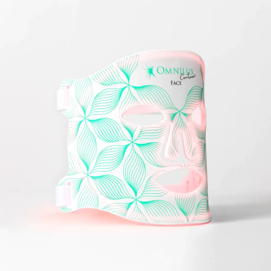 a soft, flexible face mask with a white base and mint green leaf patterns featuring pink accents around the eye and mouth openings designed for the minilux collagen anti aging beauty instrument.