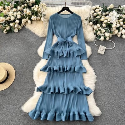 a long-sleeved tiered blue dress with ruffled layers and a matching belt tied at the waist featuring cake heavy industry pleated design.