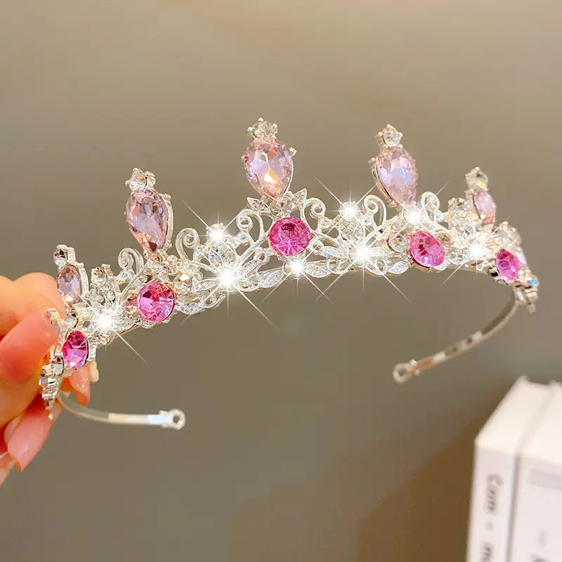A sparkling silver crown headband adorned with pink and clear crystals in an ornate design from sweet fashion jewelry hair accessories collection.
