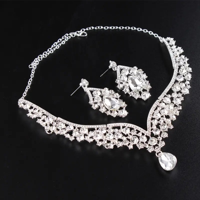 Silver rhinestone necklace with a flowing ornate design and dangling teardrop pendant from the alloy diamond accessories floral crystal jewelry set.
