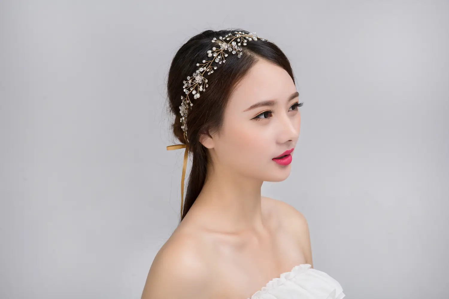 Delicate gold-toned silver crystal bridal hair accessory featuring intricate floral designs and sparkling clear crystals for elegant bridal use.