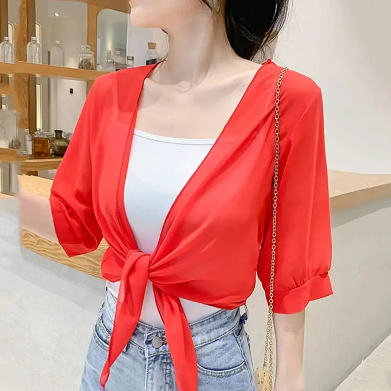 red lightweight chiffon wrap top with puffed sleeves and front tie detail paired with blue chiffon short shawl summer coat for an elegant summer coat sun outfit