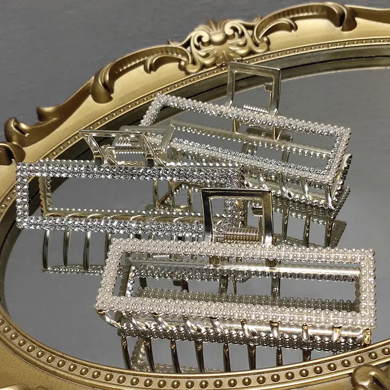 Elegant sweet pearl silver claw clip featuring silver rectangular hair clips adorned with sparkling rhinestones along their edges.