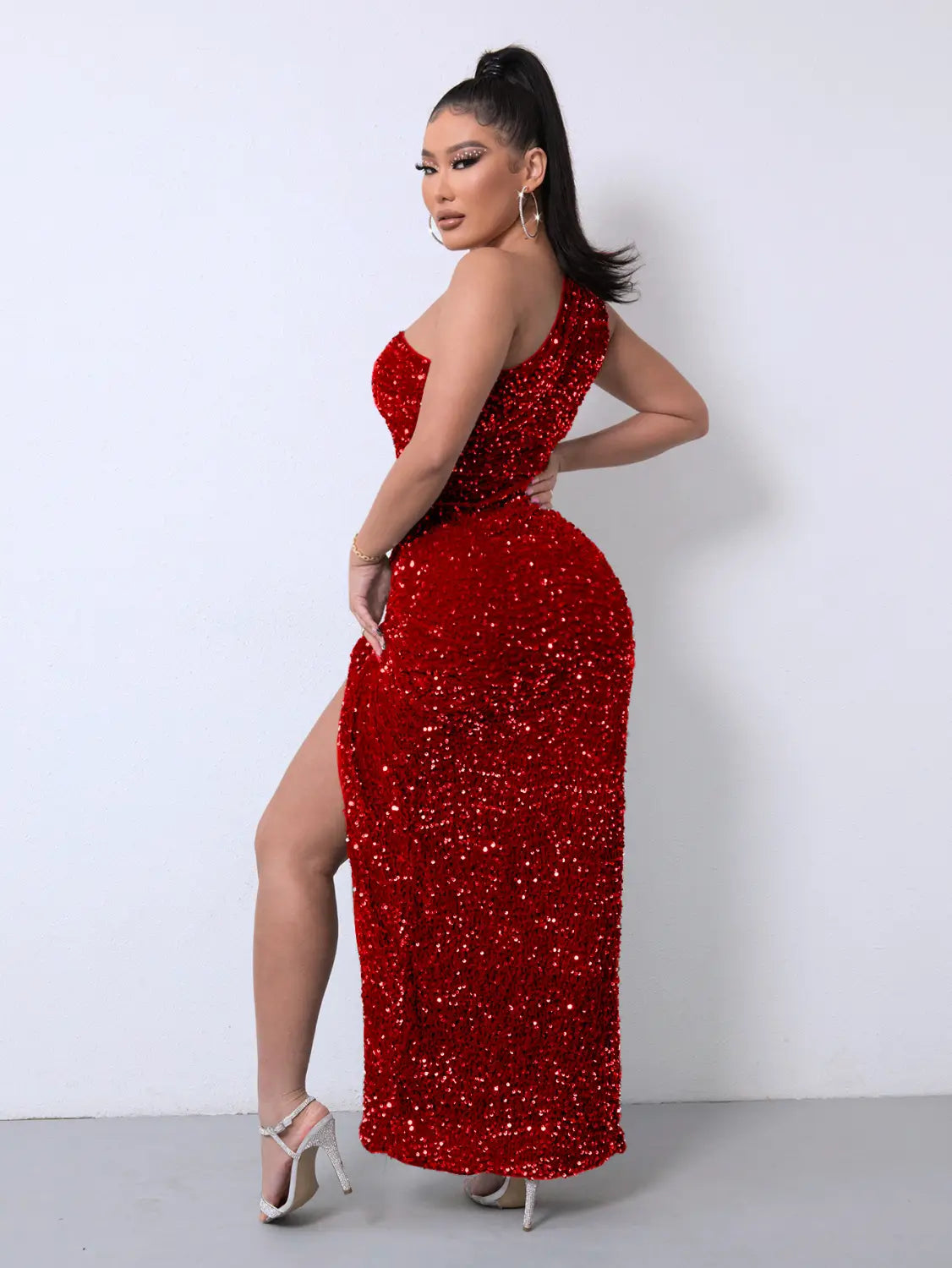 A shimmering red one shoulder slash neck sequins slit dress with a fitted silhouette and high slit showcasing foreign trade sleeveless style.