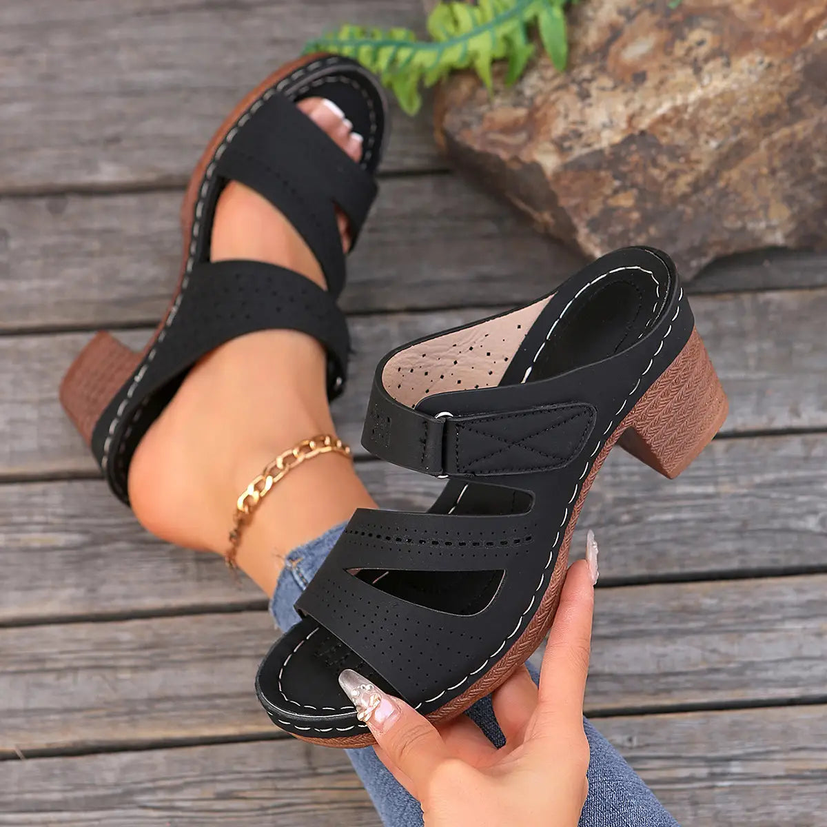 black perforated strap mule sandals with a chunky brown heel and white stitching designed as summer casual chunky shoes ideal for slides shoes summer wear