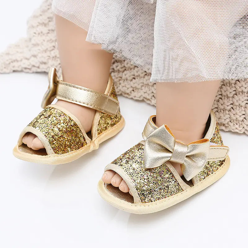 Gold sequined baby shoes princess sandals featuring glitter baby sandals with a metallic bow on the strap.