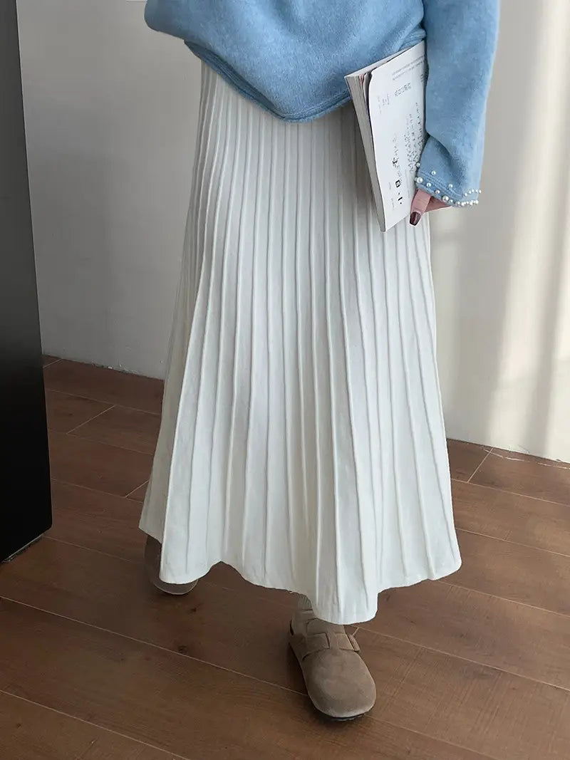 a flowing white pleated midi skirt made of soft lightweight fabric featuring a korean elastic waist knitted design that drapes elegantly