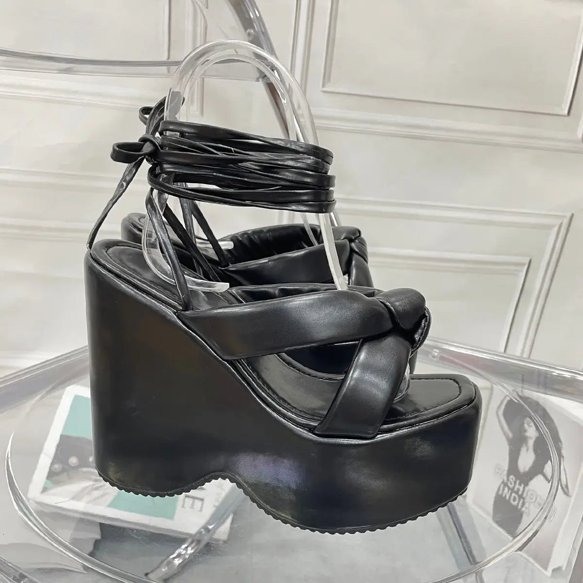 Black platform wedge high heel sandals with glossy leather finish and crisscross ankle straps.