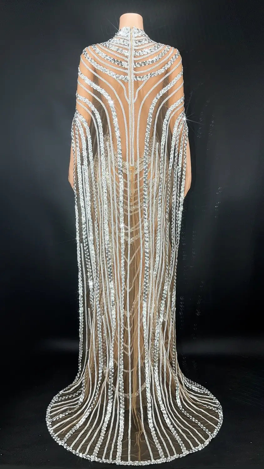 a shimmering silver beaded cape with intricate geometric patterns and flowing fringe designed to complement a red beaded celebrate crystal sequin evening gown