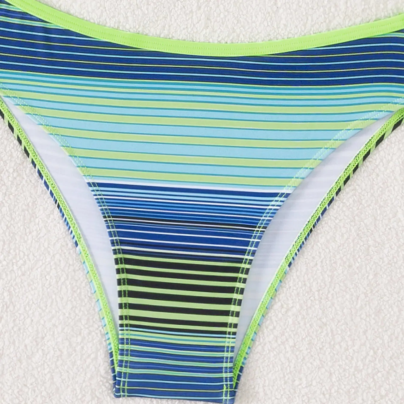 A vibrant blue and lime green striped printed split bikini bottom with white inner lining from the lime green navy striped printed split bikini swimsuit collection.