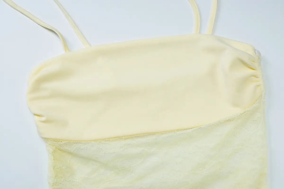 a pale yellow sleeveless camisole top with thin spaghetti straps and a gathered neckline paired with a burgundy satin y2k lace suspender dress