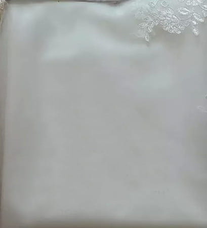 a delicate white lace-trimmed satin pillowcase with a soft smooth texture and subtle sheen complements the main fabric of the princess bride mermaid lace wedding dress.