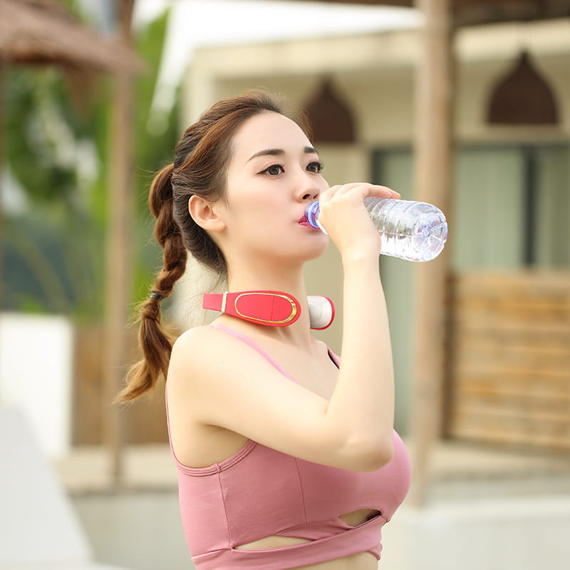 a woman wearing a red and white electric smart shoulder massager around her neck designed for heating pain relief