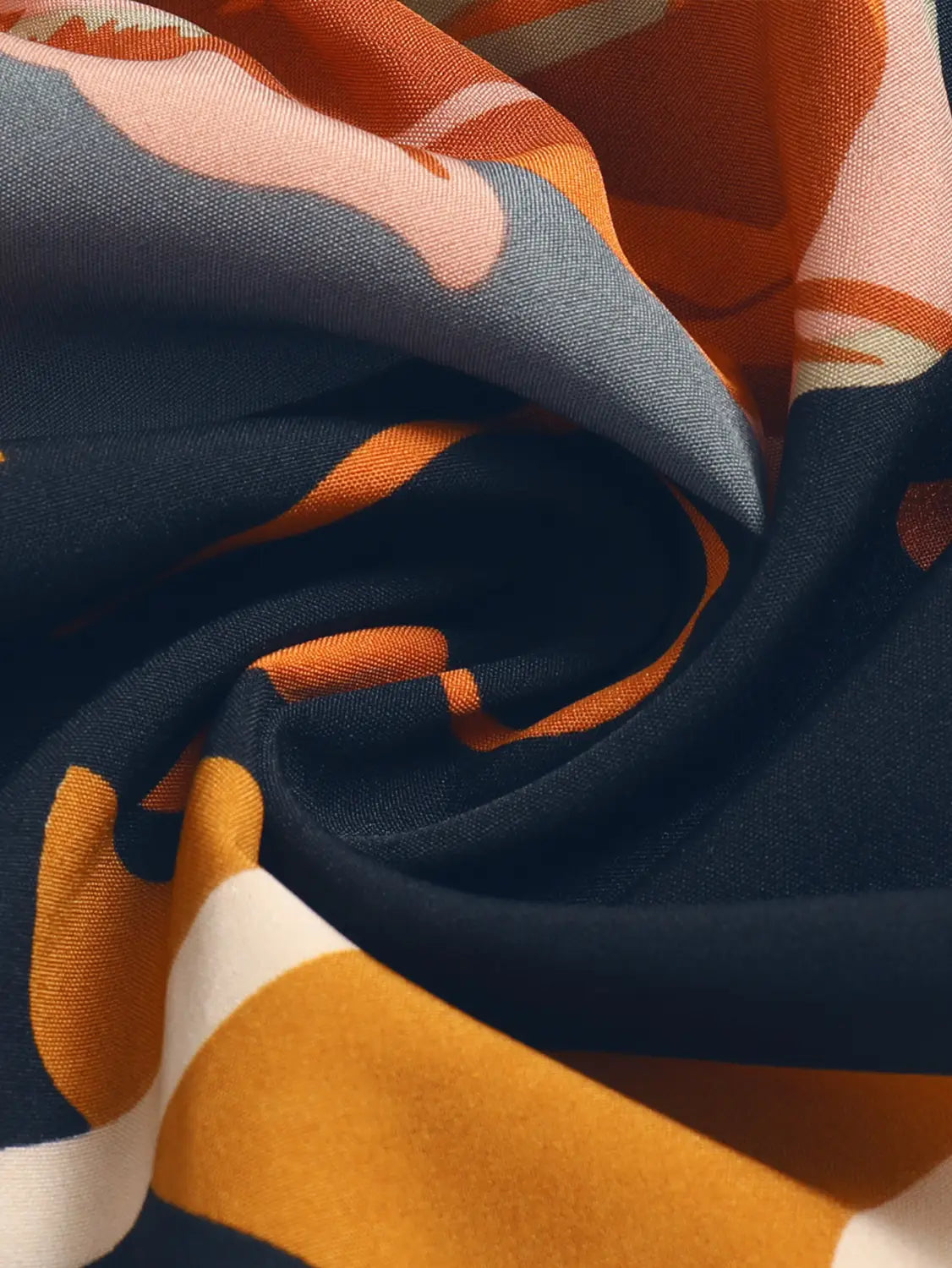 a cream tiered pleated floral print elastic waist skirt paired with a soft flowing scarf featuring a bold abstract pattern in navy blue orange and white