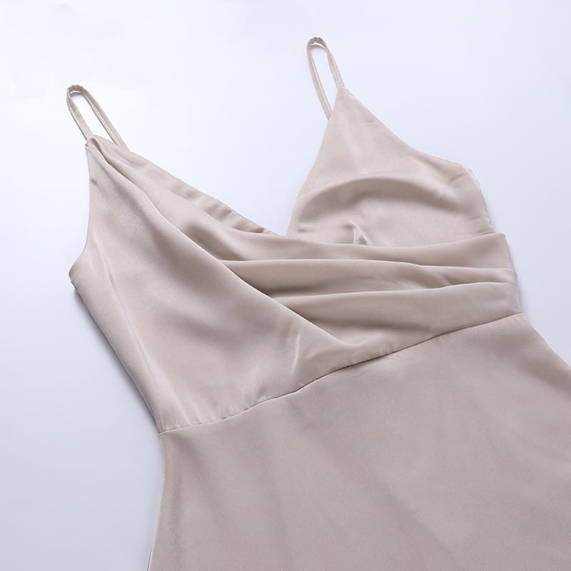 beige satin slip dress with thin spaghetti straps and a draped v-neckline ideal for sling dress summer fashion with a stylish slit design