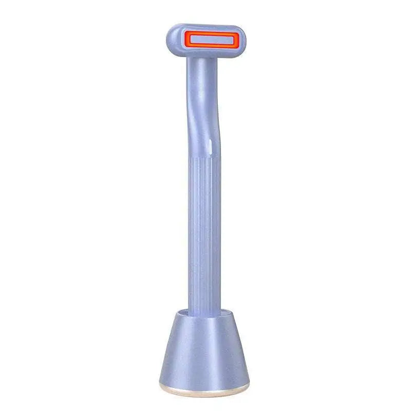 Light blue plastic rotary eye massage wand with ribbed handle and orange illuminated tip offering therapeutic warmth