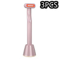 Pink rose gold 5-in-1 rotary eye massage wand with therapeutic warmth featuring a ribbed handle and orange-lit tip in base