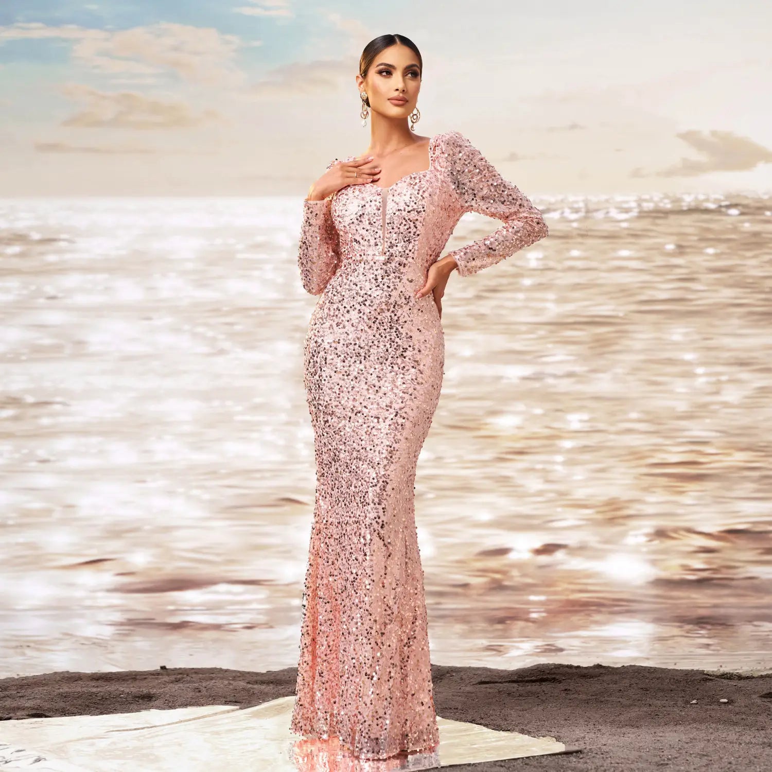 A shimmering pink sequined sheath fishtail evening dress featuring long sleeves and a square neckline.