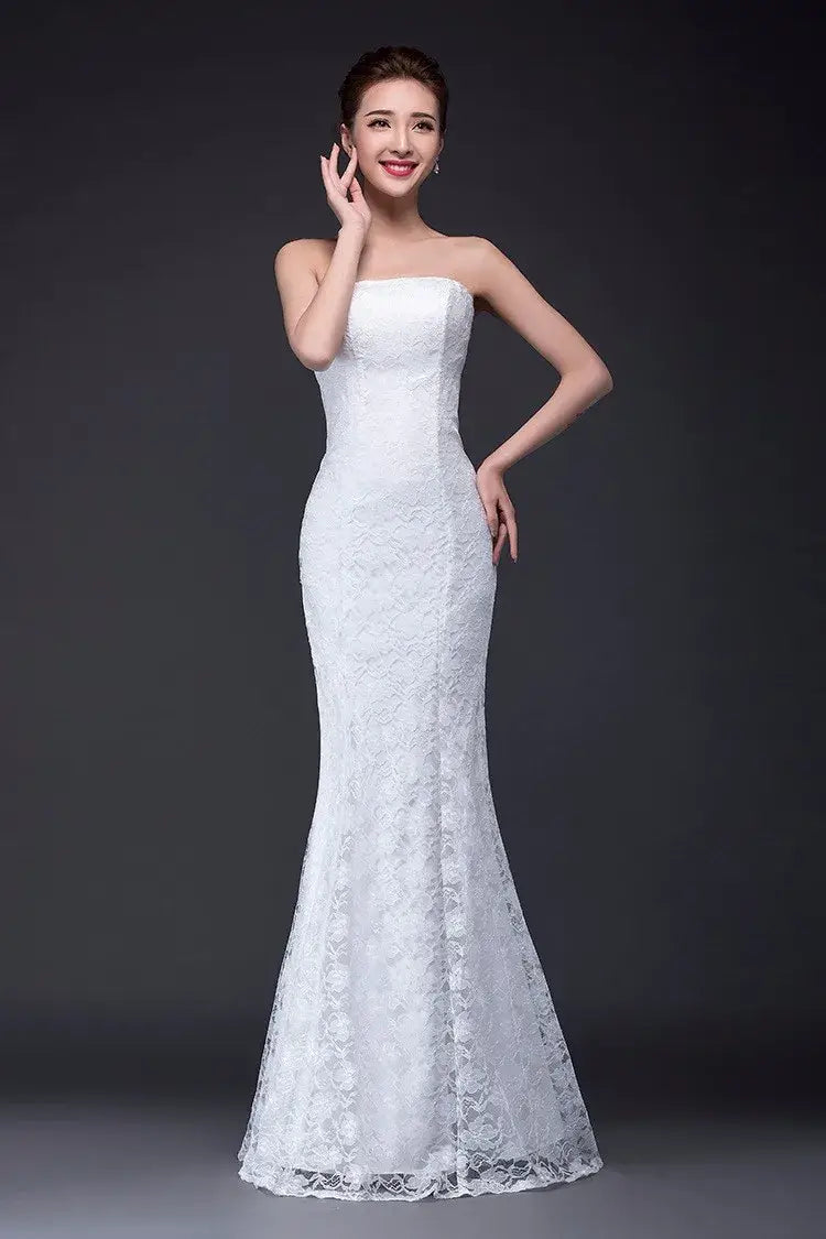 A white lace mermaid-style wedding dress with a strapless bodice and intricate floral patterns, featured as a long dress fuchsia option.