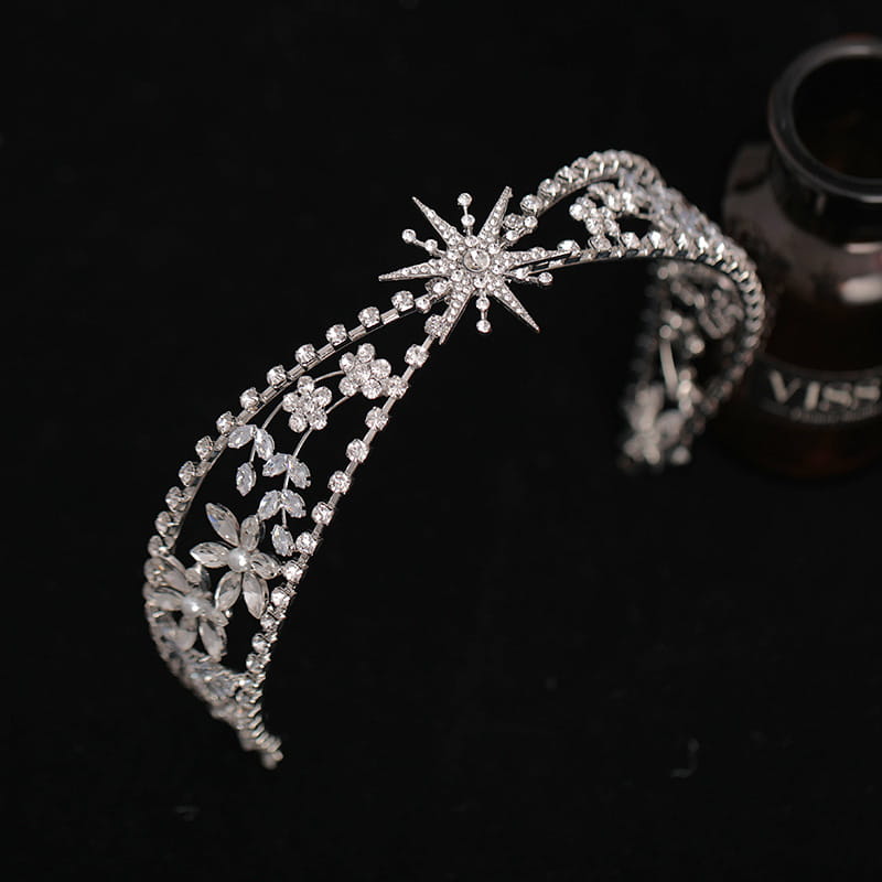 A sparkling silver bridal crown headdress featuring intricate floral and starburst designs with clear zircon crystals set in a delicate metal framework.