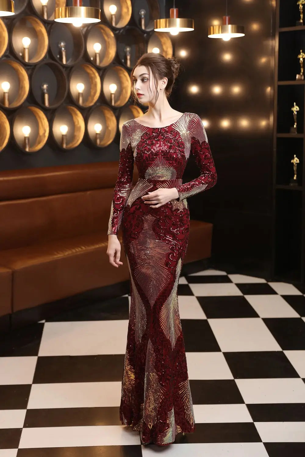 a shimmering burgundy and gold sequined mermaid-style gown with long sleeves featuring intricate fashion stitching mopping long design.