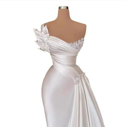 A white graceful satin off-the-shoulder wedding dress featuring intricate beaded detailing along the neckline and a draped side panel.