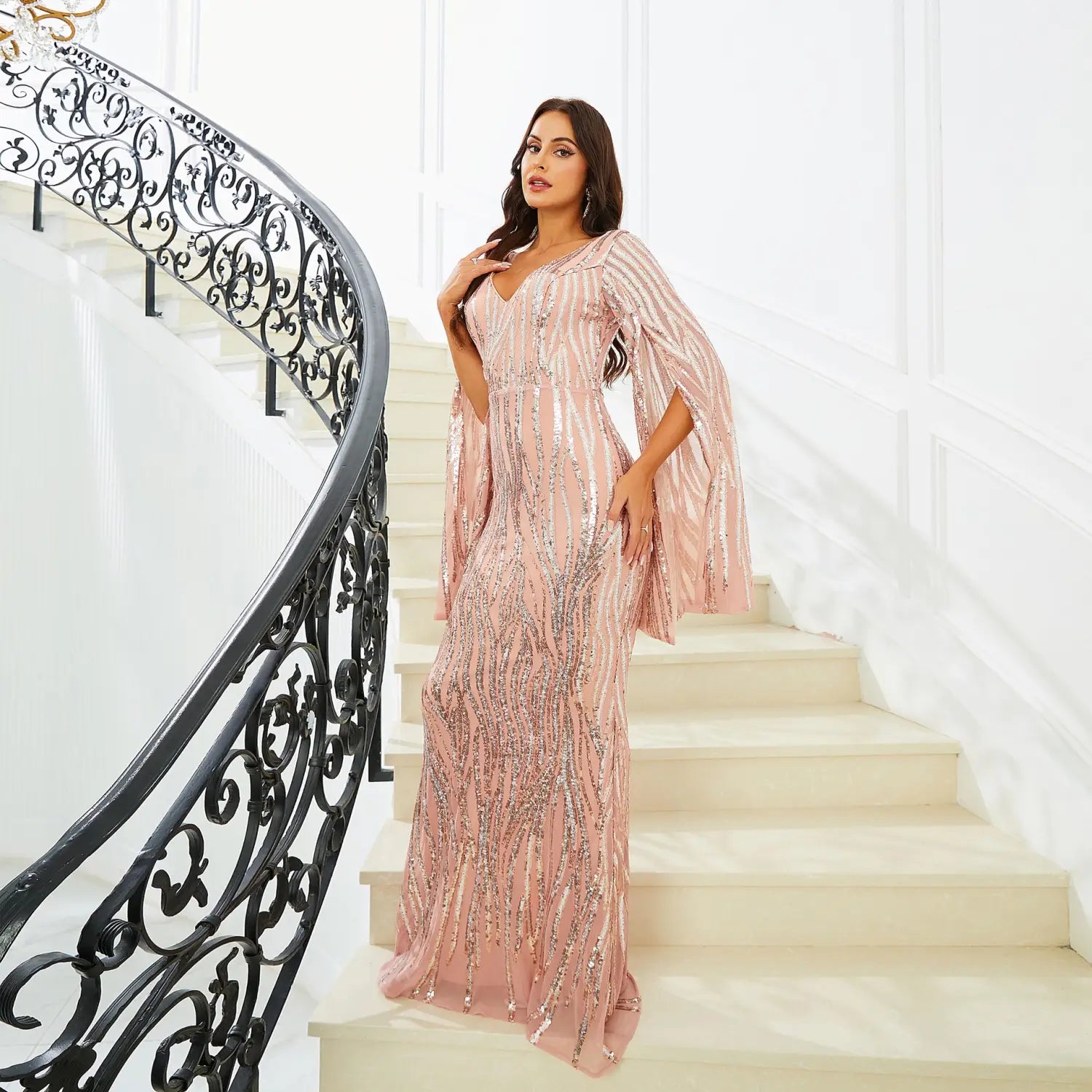 a shimmering rose gold long sleeve banquet sequined fishtail dress featuring flowing cape sleeves and intricate sequin detailing